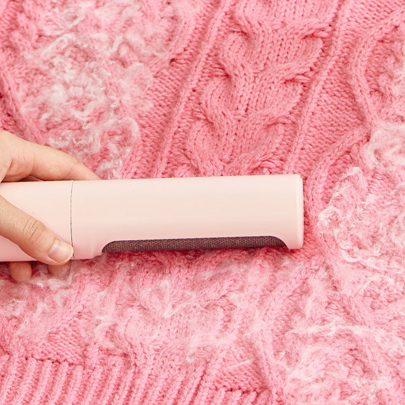 Pink reusable pet hair remover brush on knitted fabric