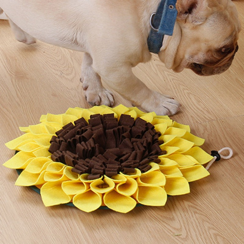Dog playing with a sunflower-shaped snuffle mat on a wooden floor