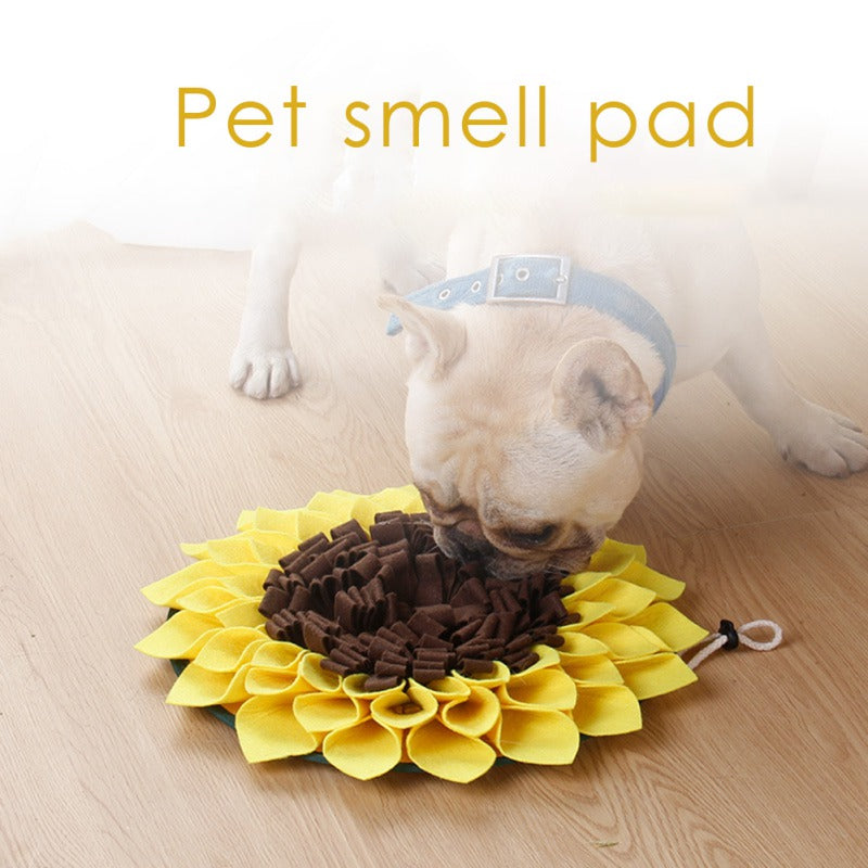 Dog using a sunflower-shaped snuffle mat on a wooden floor