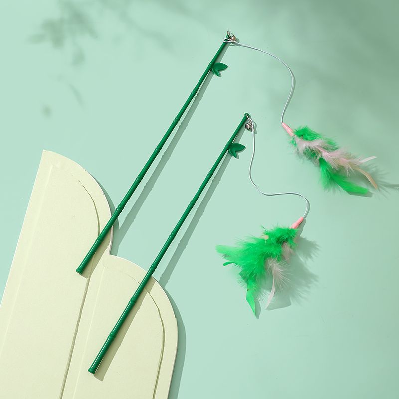 Green interactive feather wand cat toy on a soft green background