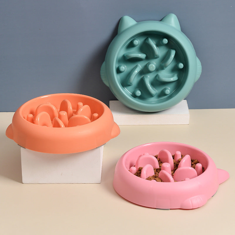 Three colourful textured slow feeder bowls on a neutral background